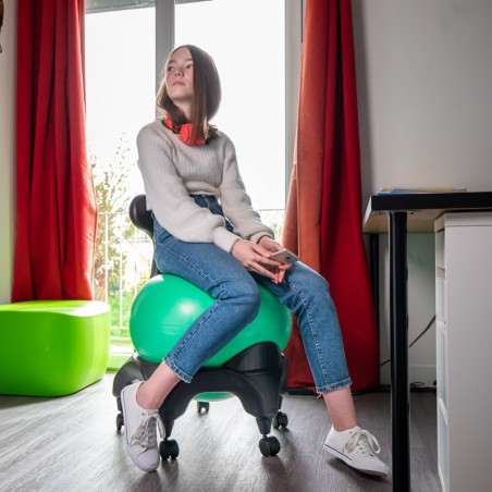 Adolescente assise sur la Tonic Chair originale verte