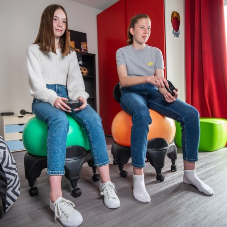 Deux adolescente assisent sur la Tonic Chair Originale Orange entrain de jouer à la console